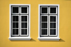 two Houston residential glass windows against yellow wall